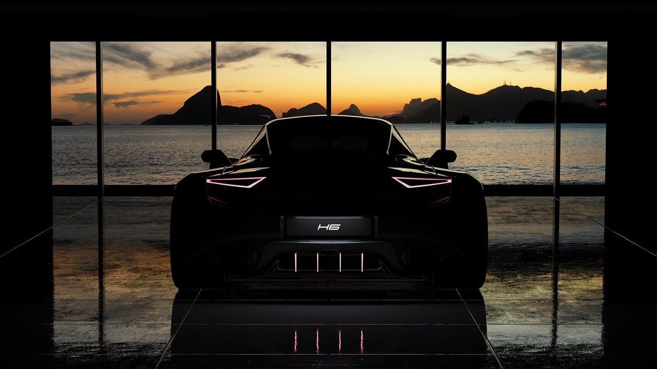 Auto sportiva nera vista da dietro, in una sala con vetrate che si affacciano sul mare e sulle montagne al tramonto.